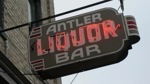 neon sign outside the antler bar in pentwater michigan with the word liquor in red. Photo by BF Newhall