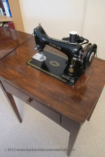 A vintage black and gold Singer sewing machine in a cabinet. Photo by Barbara Newhall