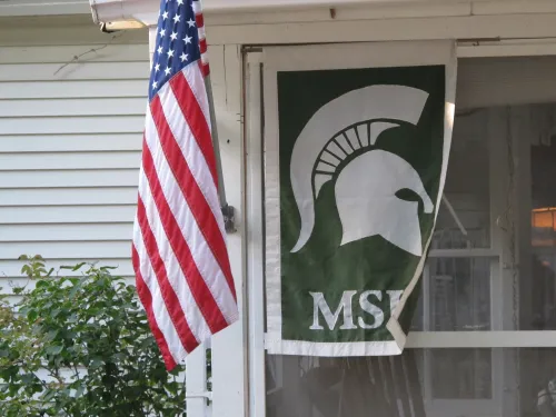 American flag flies next to a Michigan State University Trojans banner. Lots of Michigan State fans in Pentwater. Photo by Barbara Newhall
