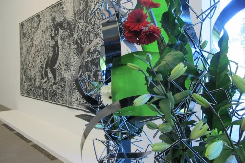 A floral design, "Eclosion" by Thanh Ngugen, accompanies r Keith Haring's painting "Untitled" 1986 at the annual Bouquets to Art show at the DeYoung Museuam. Photo by Barbara Newhall