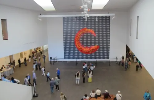 Large red C-shaped floral arrangement, "Concentrik," by Waterlily Pond Studio welcomes visitors to the Bouquets to Art show at the DeYoung Museum in San Francisco. 