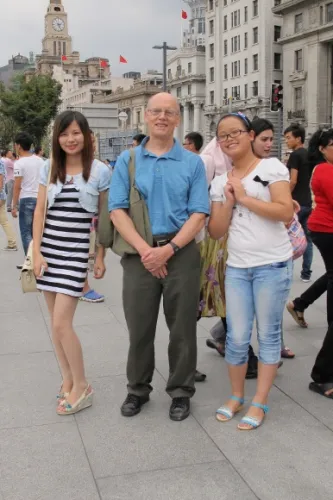 western-man-china China's young fashionistas. Two stylish Chinese girls mug for the camera with a Western man (Jon Newhall) in a polo shirt. Photo by Barbara Newhall