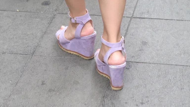 feminine feminist oxymoron Super high -- feminine? -- wedge-heeled shoes worn by a woman in Shanghai. Photo by Barbara Newhall