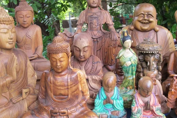 An array of wood carvings of gods and goddesses including buddha and ganesh on display table at Himalayan Fair Berkeley, May 2014. Photo by BF Newhall