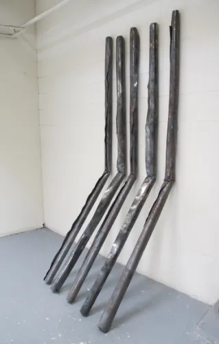 Kanyusik-sculpture. A Christopher Kanyusik sculpture of five 4x8-foot sheets of steel rolled and bent and leaning against a wall. Photo by Bf Newhall