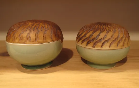 By Itsuko Zenitani, two round, fine porcelain ceramic bowls with ceramic lids-\that appear to be straw. At the Berkeley Potters Guild. Photo by BF Newhall  