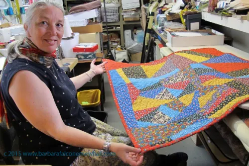 Sue Mary Fox shows off the calico quilt that she stitched together and quilted for a client. It is Barbara Falconer Newhall's crazy quilt. Photo by Barbara Newhall