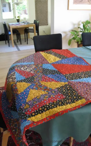 A crazy quilt made of vintage, mid-century patterned calico in primary colors designed by Barbara Falconer Newhall for her brother and his wife. Photo by Barbara Newhall