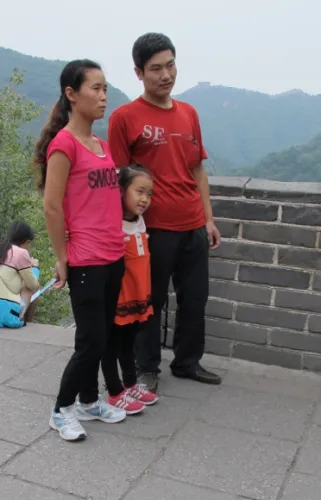An Asian family that seems to be one-child gets its picture taken on the Great Wall of China. Photo by BF Newhall