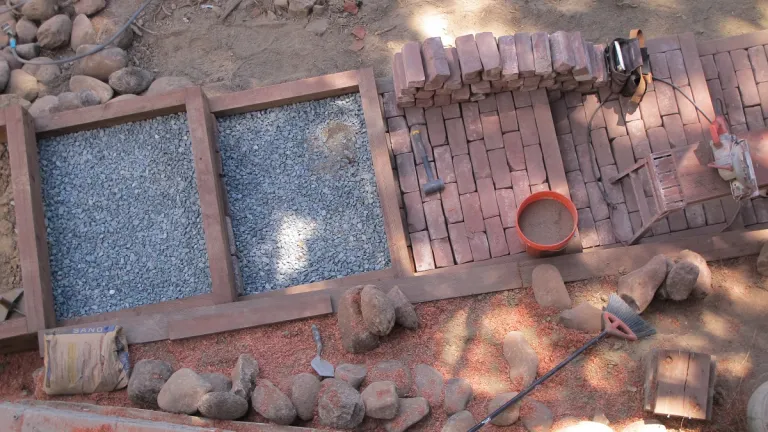 the widow laughs with pleasure at the progress of brick-stair-construction