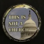 A button displaying the dome of a captol has the words "This is not a church.: photo by Barbara Newhall