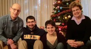 a family of four poses for a christmas photo in front of the tree. Photo by BF Newhall