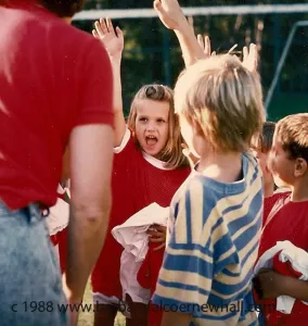 Six-year-olds in red soccer uniforms cheer their team. Photo by Barbara Newhall