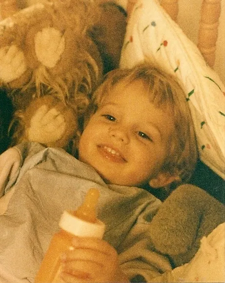 the art of rhetoric as mastered by a Tw0-year-old girl giggles with bottle in crib. Photo by BF Newhall