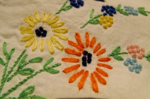 grandmother's-embroidered-pillowcase-orange-daisies-horizontal (580x387) hand embroider pillowcase with french knots & daisies. Photo by BF Newhall.