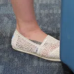 A woman with a tattoo on her foot wears lacy white huarches. Photo by BF Newhall