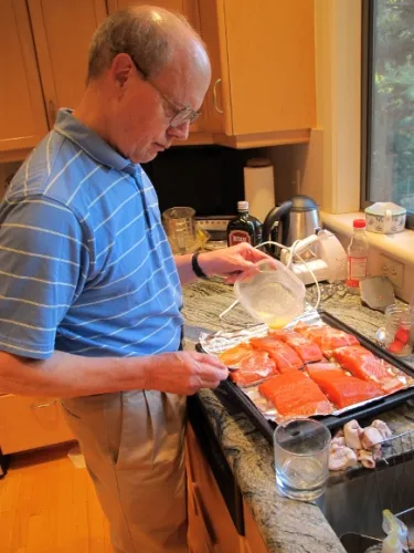 i forgot to make dinner. Jon Newhall at the kitchen counter preparing salmon to bake for his wife's birthday. Photo by Barbara Newhall