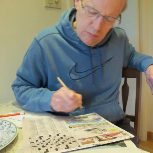 stories about my husband - jon Newhall works the Sunday NYT crossword puzzle in the SF Chronicle. Photo by Barbara Newhall