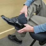 The father of the groom tries on patent leather formal shoes for the wedding at Men's Wearhouse. Photo by BF Newhall