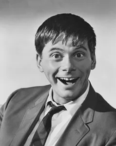 A black and white photo of actor Robert Morse as a young comedian gawking for the camera.