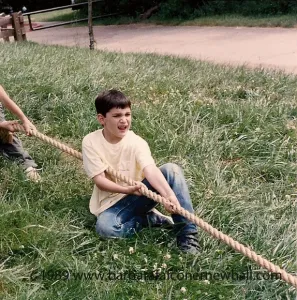 An eight-year-old boy pulls on a rope in tug of war. Photo by Barbara Newhall
