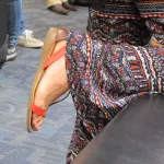 A woman at SFO wears orange sandals and paisley pants. Photo by BF Newhall