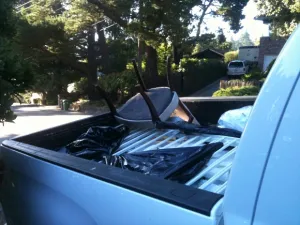 pink needlepointed chair upside down in back of pick-up truck. Photo by BF Newhall.