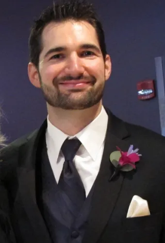 Handsome groom in tux, vest and tie with pink boutonniere before his wedding. Photo by BF Newhall