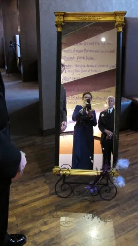 Names of the participants in a wedding are written on the face of an old-fashioned mirror. Photographer & writer Barbara Falconer Newhall can be seen in its reflection. Photo by BF Newhall